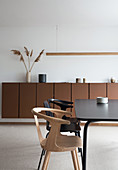 Black dining table with chairs in front of brown sideboard