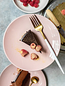 Chocolate truffle cake with raspberries and chocolate decoration on top on the plate