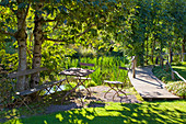 Sitzplatz neben dem Steg am See im sonnigen Garten