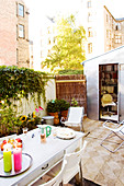 A table laid in a back garden with a mini-office in a garden house