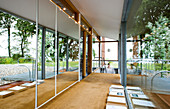 Glazed wall in the hallway with a jute rug and windows