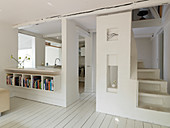 Open living room in white with spiral staircase and open kitchen