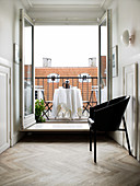 Black designer chair in front of an open balcony door