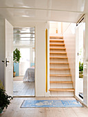 A hallway with stairs and a view into the bedroom on a houseboat