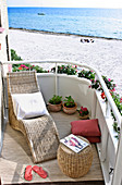 Wicker chaise lounge on a seaside sunny terrace