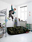 Boy jumps from the loft bed onto a beanbag