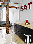 Red lettering above the black kitchenette in the open living room