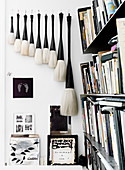 Collection of large brushes on the wall next to the bookshelf