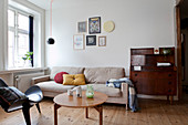 Antiker Sekretär, sandfarbene Couch, Coffeetable und Designerstuhl im Wohnzimmer