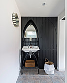 Antique sink and washstand against black wooden wall in converted barn