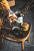 A person pours coffee from carafe into an enamel mug