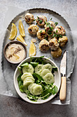 Köttbullar (Swedish meatballs) served with a creamy sauce and a cucumber salad on a tray