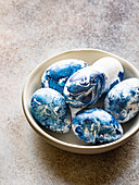 A bowl of blue marbled Easter eggs