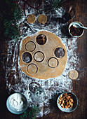 Gingerbread dough with cut-out biscuits on a wooden surface
