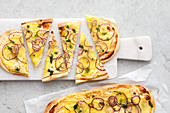 Potato tarte flambée with red onions and dill oil