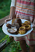 Frau serviert Lammrollbraten mit Popovers