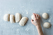 Bread dough being shaped into rolls
