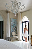 Woman wearing white summer dress in Mediterranan bedroom