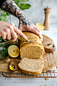 Person cuts a knife bread with lemon and Parmesan cheese