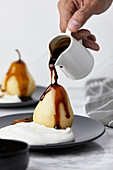 Poached pears with spices served with mascarpone and cream, topped with caramel sauce
