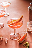 Grapefruit margarita cocktail on ice with pink salt and lime