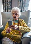 Care home resident looking at smartphone photos