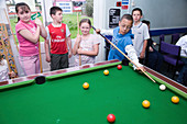 Child learning to play pool