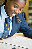 Secondary school student reading a newspaper