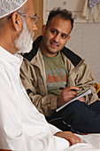 Social worker interviewing elderly man at home