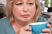 Thoughtful woman drinking tea
