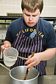 Teenaged boy with Down Syndrome learning to cook