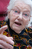 Woman with Alzheimer's disease pointing whilst chatting