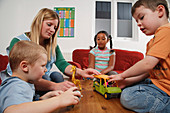 Nursery nurse with children playing with toys