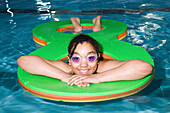Girl playing with inflatable float in swimming pool