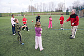 Group of children throwing and catching a tennis ball