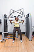 Young woman using a chest press machine