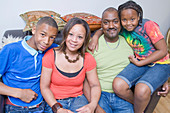 Portrait of family sitting on the sofa at home together