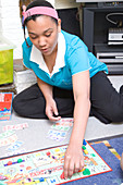 Teenaged girl playing a game of Monopoly