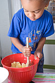 Little boy stirring a mixing bowl