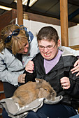 Young woman with learning disabilities with a large rabbit