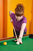 Girl playing pool in youth club