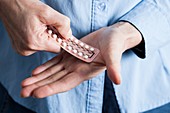 Hands holding hormone replacement therapy pills
