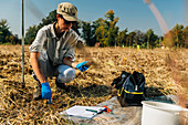 Soil scientist measuring soil temperature