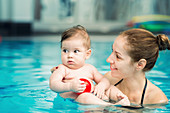 Baby and mother in swimming pool