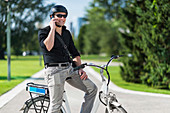 Businessman on electric bicycle talking on the phone