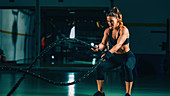 Woman exercising with battle ropes
