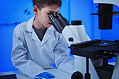 Schoolboy using light microscope