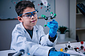 Schoolboy holding molecular model