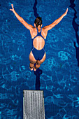 Woman diving into pool from springboard