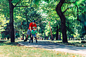 Father teaching son to roller skate in park